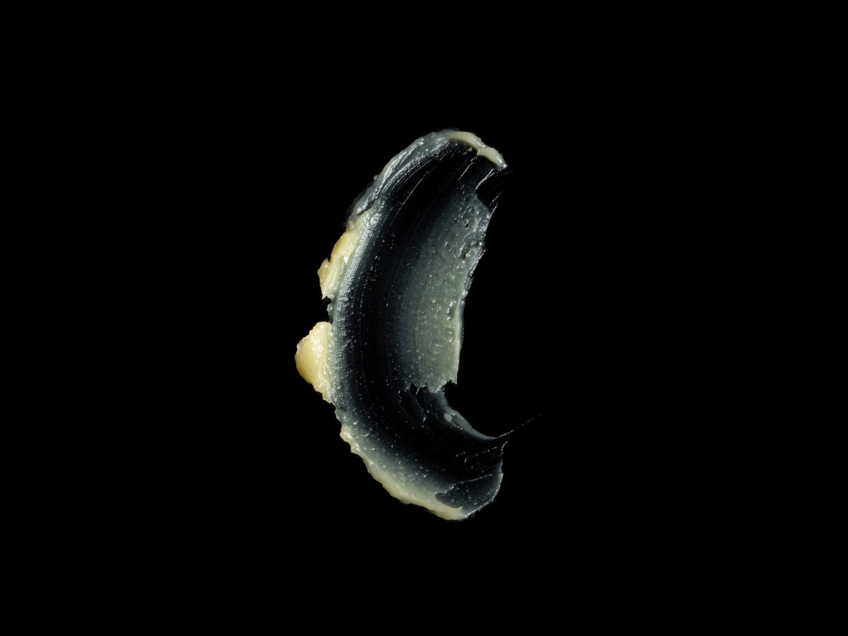 Swatch of Helichrysum Body/Face BALM texture on a black background