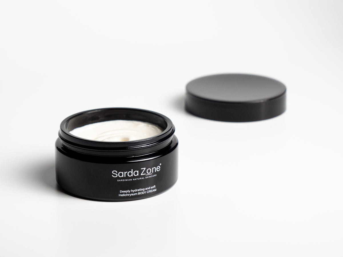 Open jar of Sarda Zone Helichrysum Body Cream with the lid beside it