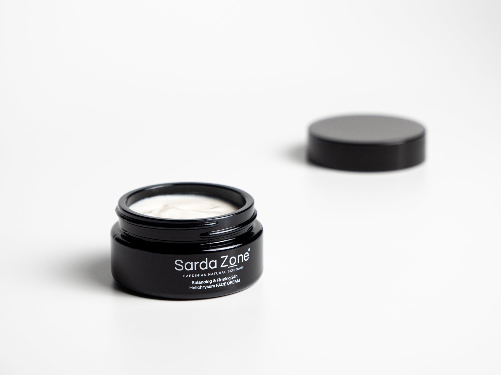 Open jar of Sarda Zone Helichrysum FACE CREAM 24h with the lid behind it